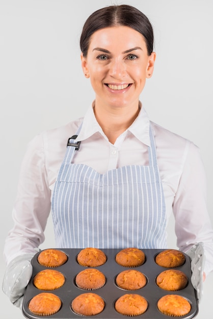 Foto gratuita confitero mujer sosteniendo cupcakes y sonriendo