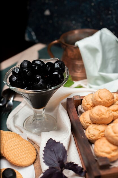 Confitura de nogal negro tradicional en un frasco de vidrio con galletas de mantequilla en una tabla de madera