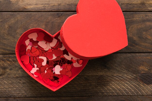 Conjunto de adornos de corazones de colores en caja actual roja.