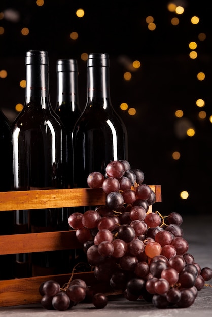 Conjunto de botellas de vino y uvas con fondo bokeh