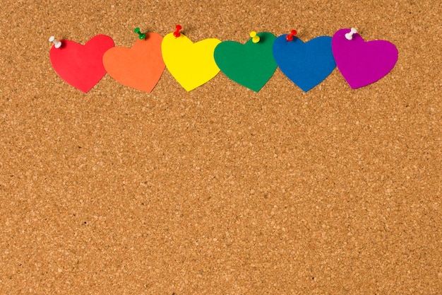 Conjunto de corazones en colores del arco iris sobre corcho