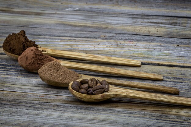 Conjunto de cuchara de madera con café, cacao bellamente arreglado sobre madera