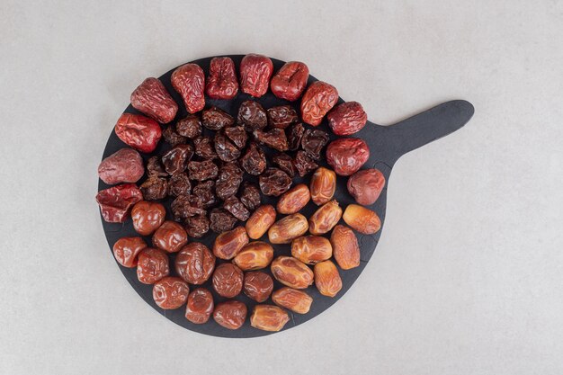 Conjunto de frutos secos en un plato de madera.