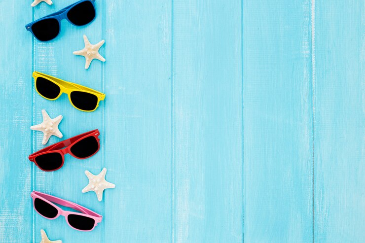 Foto gratuito conjunto de gafas de sol con estrellas de mar sobre fondo azul de madera