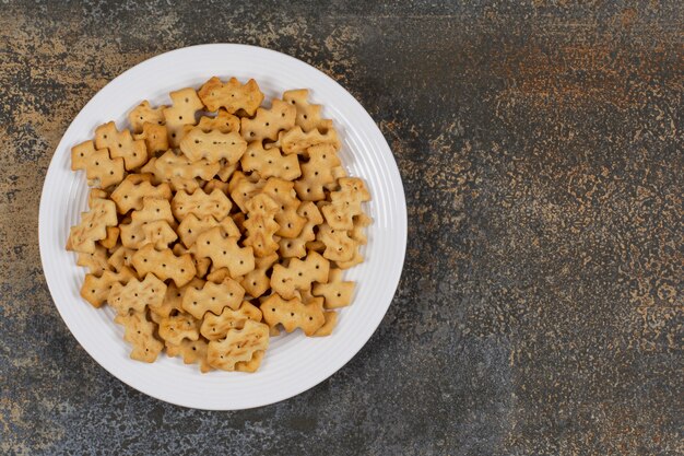 Conjunto de galletas saladas en plato blanco.