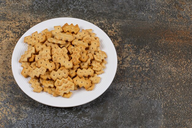 Conjunto de galletas saladas en plato blanco.