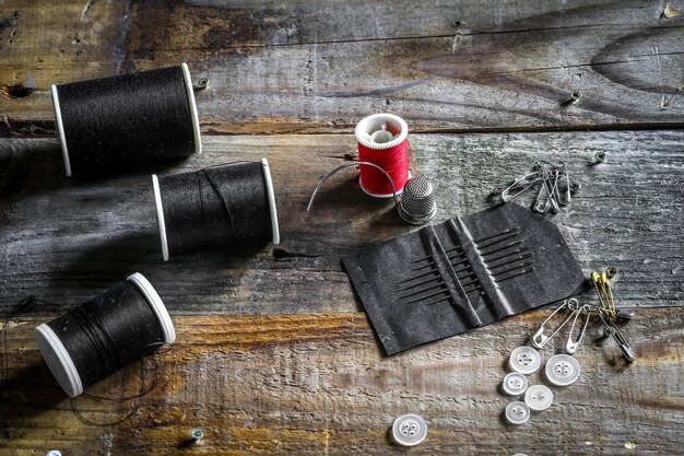 Conjunto de hilos de coser y accesorios en la pared de madera