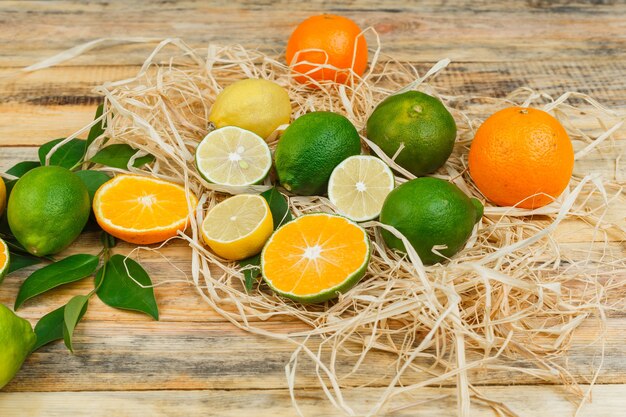 Conjunto de hojas y frutas cítricas en una tabla de madera