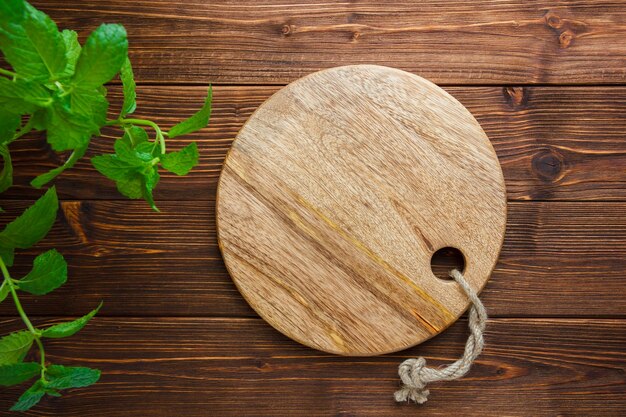 Conjunto de hojas y tabla de cortar sobre un fondo de madera. vista superior. copiar espacio para texto