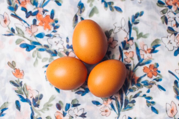 Conjunto de huevos de gallina sobre material floreado.