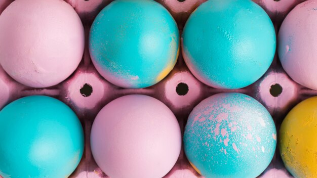 Conjunto de huevos de Pascua brillantes en contenedor rosa