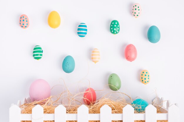 Conjunto de huevos de Pascua cerca de heno en caja