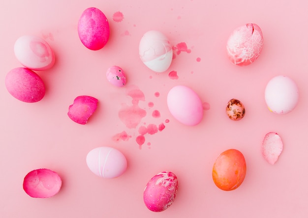 Conjunto de huevos de Pascua color de rosa y blanco entre salpicaduras de líquido de tinte