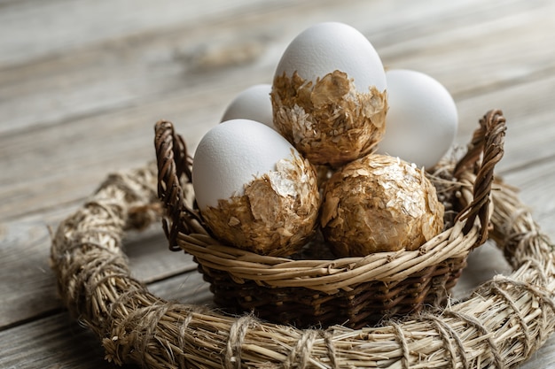 Conjunto de huevos de Pascua festivos en una cesta de mimbre sobre un fondo borroso. Concepto de vacaciones de semana Santa.