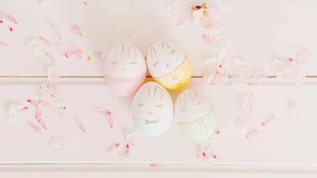 Foto gratuita conjunto de huevos de pascua entre pétalos de flores.
