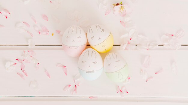 Conjunto de huevos de Pascua entre pétalos de flores.