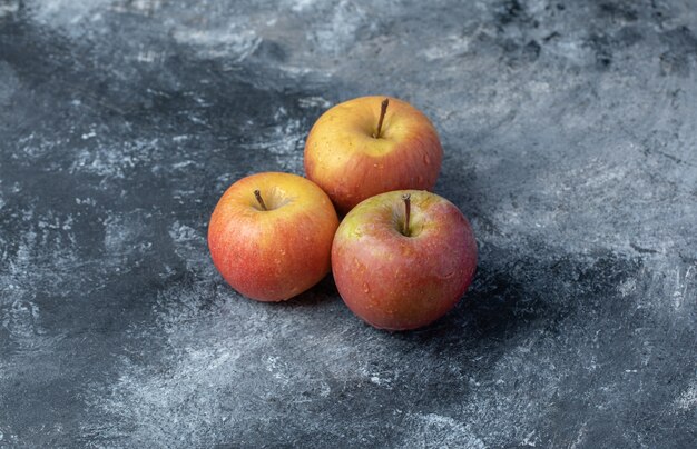 Conjunto de manzana amarilla roja fresca sobre fondo de mármol.