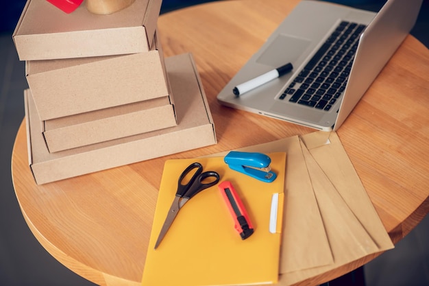 Conjunto de materiales de embalaje y una computadora portátil sobre la mesa.