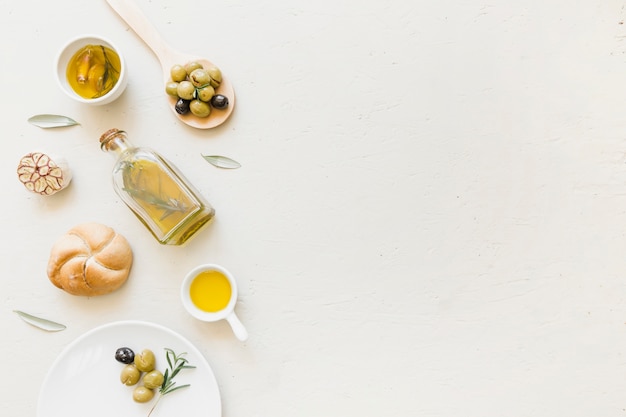 Conjunto de pan de botella de aceite y aceitunas en cuchara