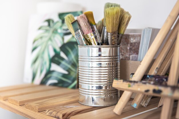 Un conjunto de pinceles para pintar en una lata en un estante del taller