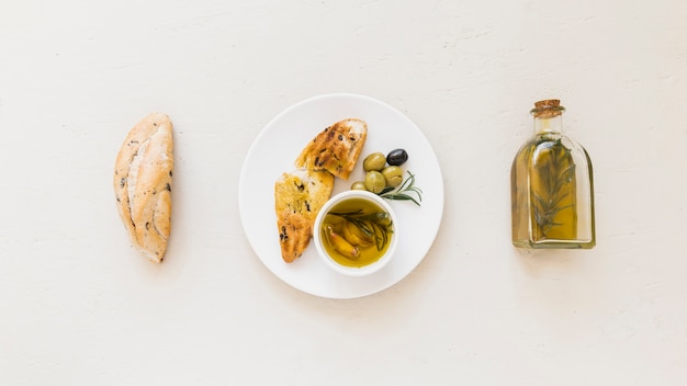 Conjunto de plato con aceite de pan y aceitunas