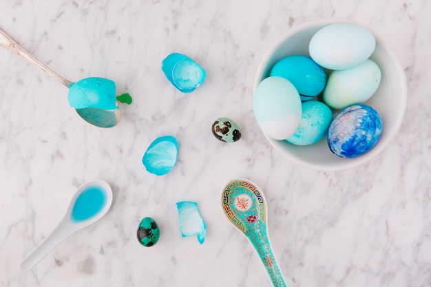 Foto gratuita conjunto de pollo colorido y codornices huevos de pascua en un tazón cerca de cucharas