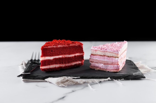 Conjunto de porciones de pastel de terciopelo y pastel de fresa en mármol