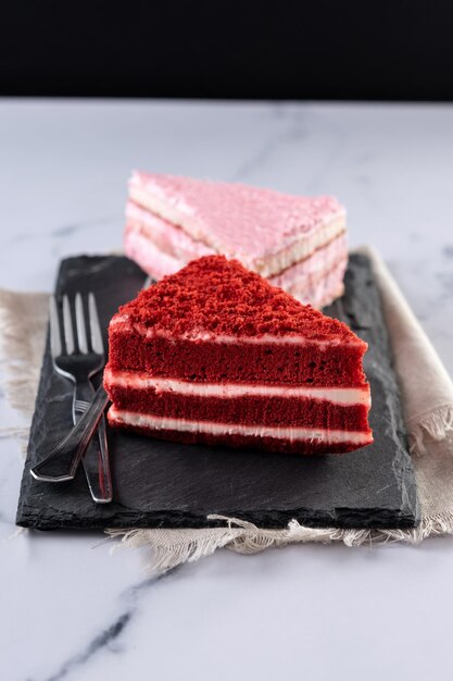 Conjunto de porciones de pastel de terciopelo y pastel de fresa en mármol