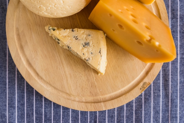 Conjunto de queso fresco sobre plancha de madera sobre mesa