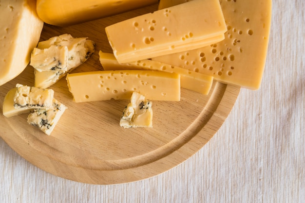 Foto gratuita conjunto de queso fresco sobre tabla para cortar madera