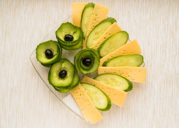 Conjunto de queso, pepino y aguacate con aceitunas en plato