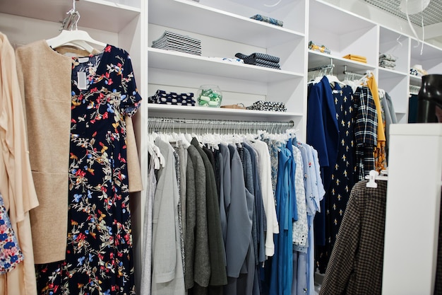 Conjunto de ropa colorida femenina en los estantes de la tienda de ropa nueva boutique moderna