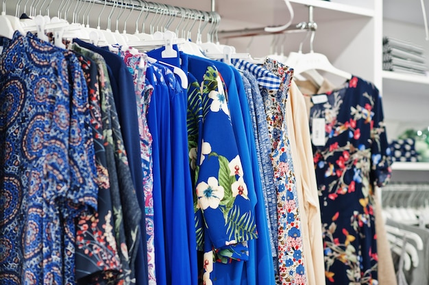 Conjunto de ropa colorida femenina en los estantes de la tienda de ropa nueva boutique moderna