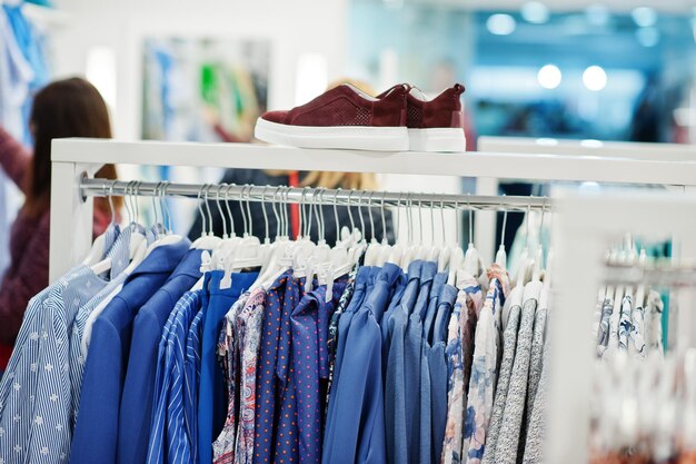 Conjunto de ropa colorida femenina en los estantes con zapatos en la tienda de ropa nueva boutique moderna