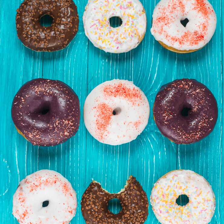 Foto gratuito conjunto de sabrosas rosquillas mordidas con cobertura de chocolate y salpicaduras