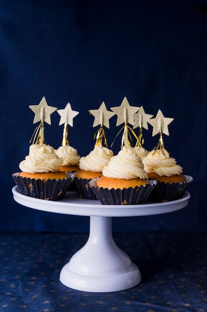 Conjunto de sabrosos pasteles con crema de mantequilla y estrellas en el stand