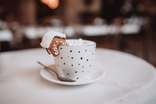 Conjunto con taza blanca para maqueta. La taza con las decoraciones navideñas y la galleta en el borde.