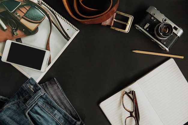 Foto gratuita conjunto turístico maqueta, jeans, correa, cámara, gafas, bloc de notas y teléfono inteligente