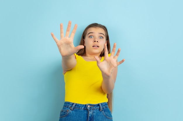 Conmocionada jovencita vestida con jeans y blusa amarilla