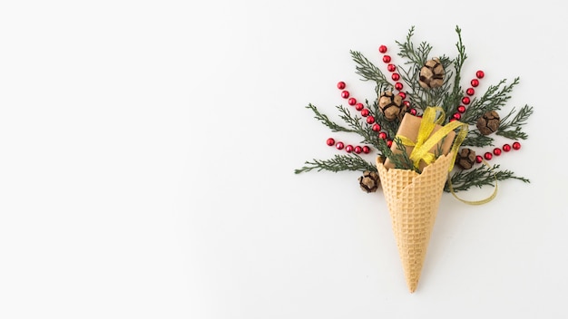 Foto gratuita cono de galleta con ramas y caja de regalo.