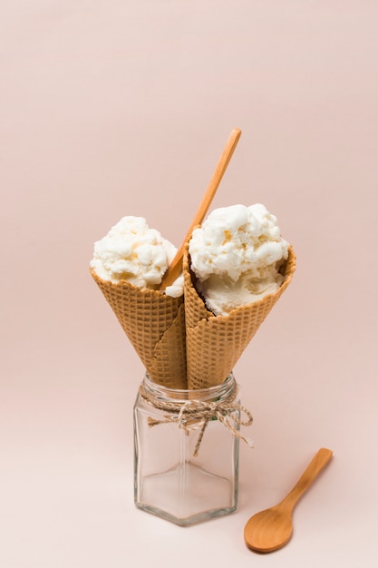 Foto gratuita conos de la galleta con helado en tarro cerca de la cuchara