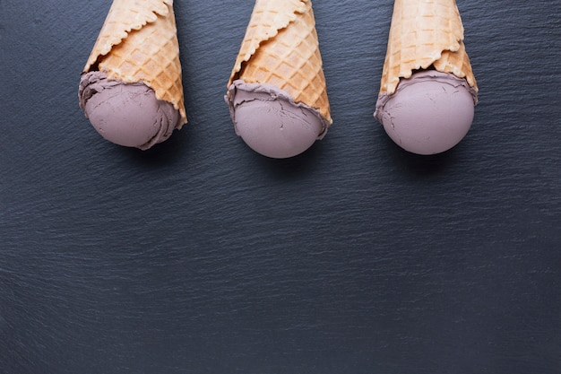 Conos de helado de chocolate en mesa negra