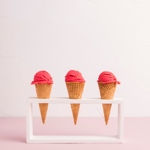 Conos de helado rojos en soporte.