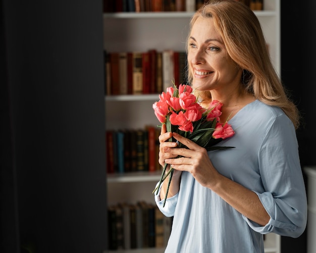 Consejero de mujer tiro medio sosteniendo ramo de flores