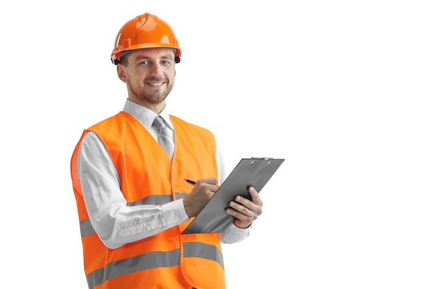 Foto gratuita el constructor en un chaleco de construcción y casco naranja de pie sobre fondo blanco de estudio. especialista en seguridad, ingeniero, industria, arquitectura, gerente, ocupación, empresario, concepto de trabajo