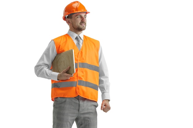 El constructor con un chaleco de construcción y un casco naranja con portátil.