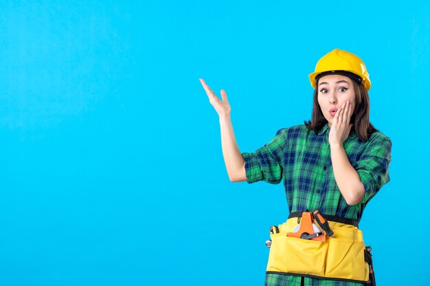 Constructor femenino de vista frontal en uniforme y casco sorprendido en azul