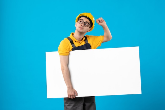 Foto gratuita constructor masculino de vista frontal en plan uniforme amarillo sobre azul