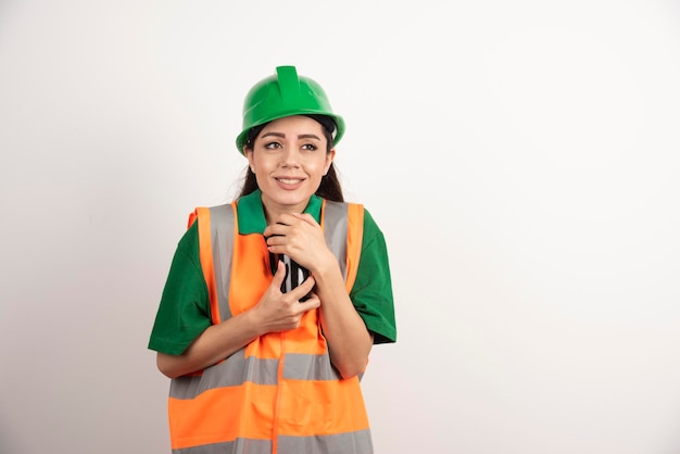 Constructor de sexo femenino joven que sostiene la taza negra. Foto de alta calidad