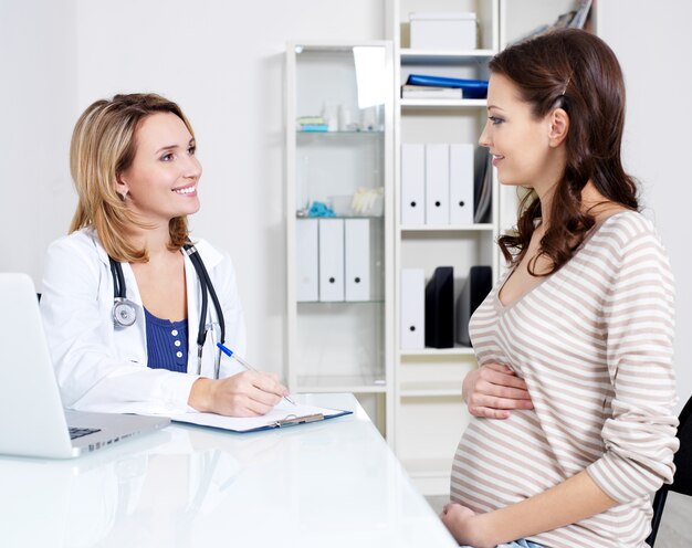 Consulta de joven embarazada con su médico